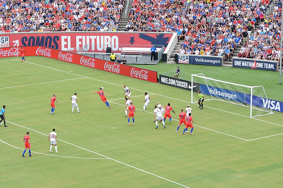 Jugador ejecutando un saque de esquina en estadio argentino