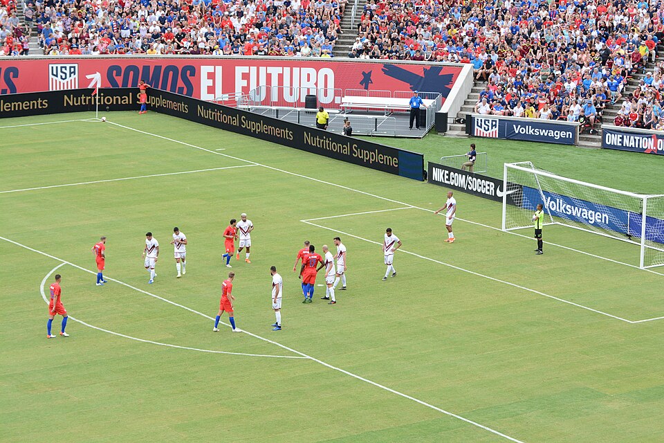 Jugador ejecutando un saque de esquina durante un partido de fútbol